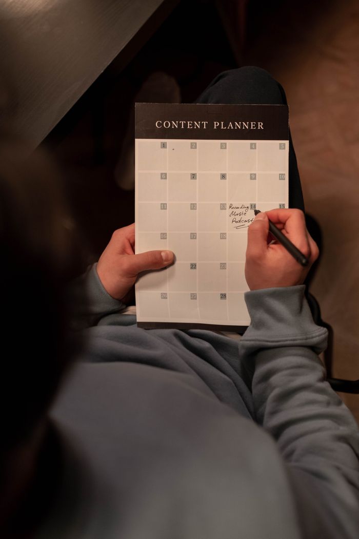 Personne en train de planifier du contenu sur un calendrier dans un cadre intérieur chaleureux.